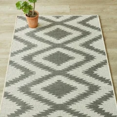Diamond Grey outdoor rug on a pale timber floor beside a terracotta pot