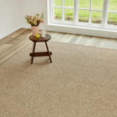 Chunky Boucle Camel outdoor rug beneath a small timber stool holding dried flowers