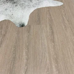 Persimmon vinyl plank flooring with the corner of a white sheepskin rug laid across it