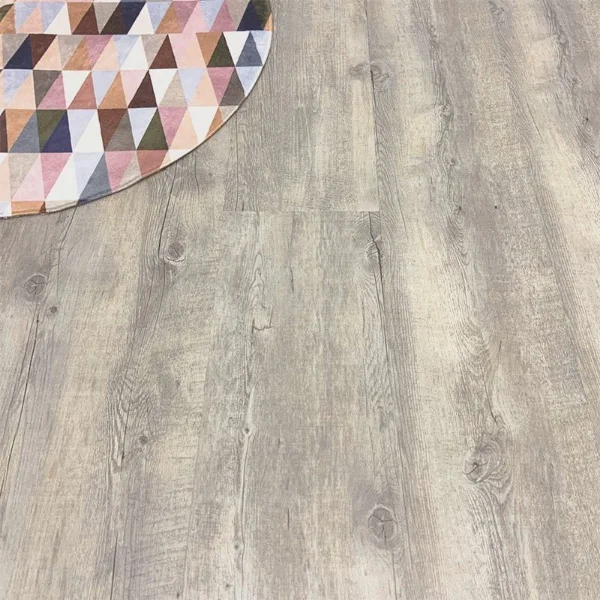 Baltic vinyl plank flooring in weathered grey-taupe, with the corner of a geometric patterned rug