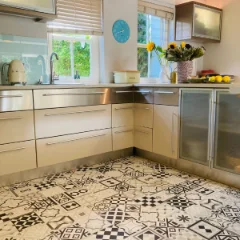 Curiosity patchwork tile vinyl in a kitchen with pale timber cabinetry