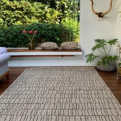 Stacks Almond outdoor rug on a covered stoep with a bench and potted plants