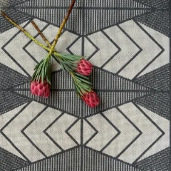 Close-up of the Mountains Grey pattern, cream chevrons against a grey flat weave