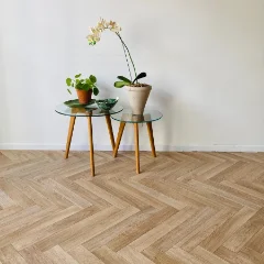 Solar Herringbone vinyl flooring beneath a glass side table holding plants and an orchid