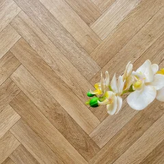 Solar Herringbone vinyl flooring with a white orchid stem laid across it