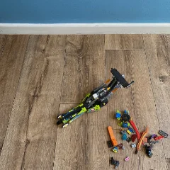 Harbour vinyl flooring with toy vehicles scattered across it, against a blue wall