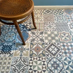 Heritage vinyl flooring in a blue and grey patchwork tile pattern, beneath a rattan stool