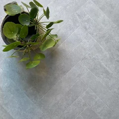 Piazza vinyl flooring in pale grey stone, with a plant in a dark pot