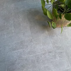 Close-up of Piazza pale grey stone vinyl with a trailing plant