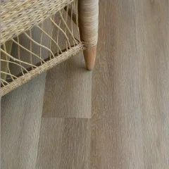 Hennops vinyl plank flooring in greige, beneath a woven cane chair on a tapered timber leg