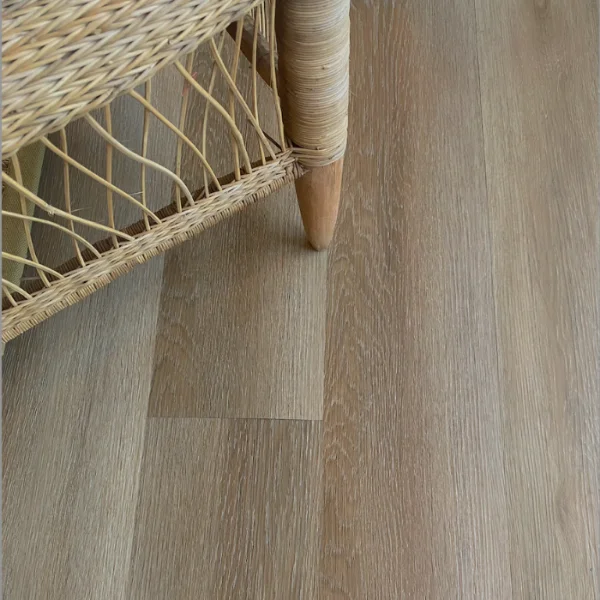 Hennops vinyl plank flooring in greige, beneath a woven cane chair on a tapered timber leg