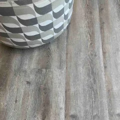 Outeniqua vinyl plank flooring in cool mid grey, with a white faceted vessel in one corner
