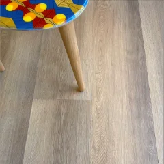 Robberg vinyl plank flooring in pale greige, beneath a stool with a brightly patterned seat