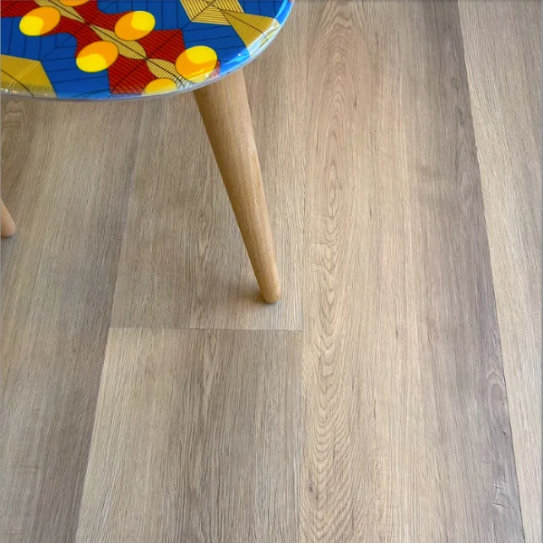 Robberg vinyl plank flooring in pale greige, beneath a stool with a brightly patterned seat