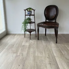 Respite vinyl flooring with a dark timber chair and tiered plant stand against a pale wall