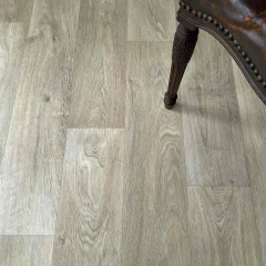 Close-up of Respite vinyl planks with a carved chair leg resting on them