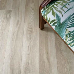 Bliss vinyl planks seen at an angle, with the corner of a botanical-print chair