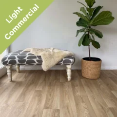 Solace vinyl flooring beneath a sheepskin-topped bench and a fiddle-leaf fig, with a Light Commercial badge
