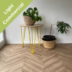 Chevron vinyl flooring with yellow hairpin plant stands against a pale wall, with a Light Commercial badge