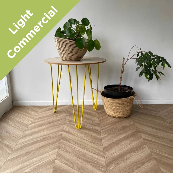 Chevron vinyl flooring with yellow hairpin plant stands against a pale wall, with a Light Commercial badge