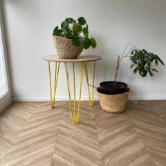 Chevron vinyl flooring with yellow hairpin plant stands and potted plants against a pale wall