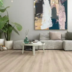 Ashen Oak laminate in a living room with a grey sofa, round coffee table and framed artwork