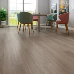 Cinder Oak laminate in a dining area with green upholstered chairs and full-height windows