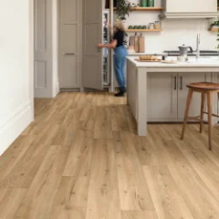 Barley Wood vinyl flooring in a kitchen, with a person standing at the island