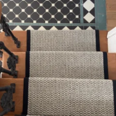 Veld Knotted Pewter fitted as a stair runner on a staircase with dark panelled walls