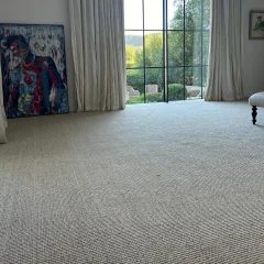 Wool Highlands carpet fitted in a living room with full-length curtains and garden doors